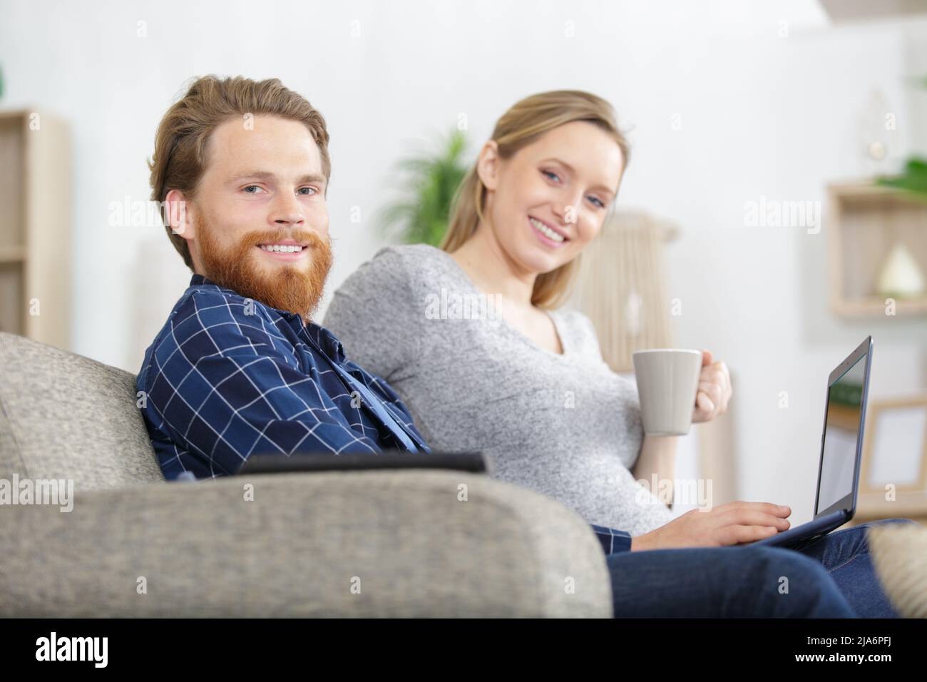 Young couple sits on sofa hi-res stock photography and images - Alamy
