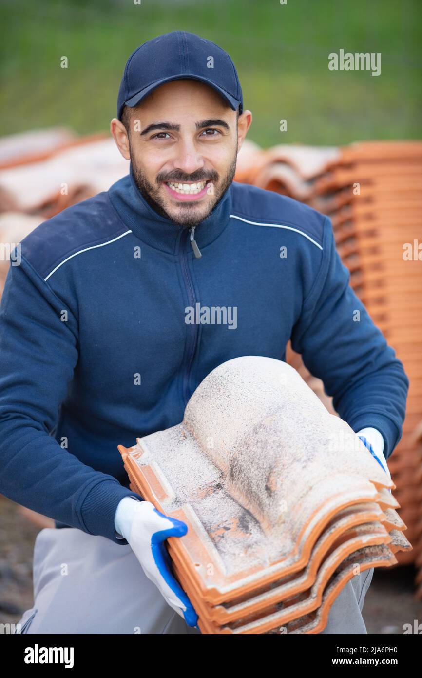 professional builder holding tiles and smiling Stock Photo