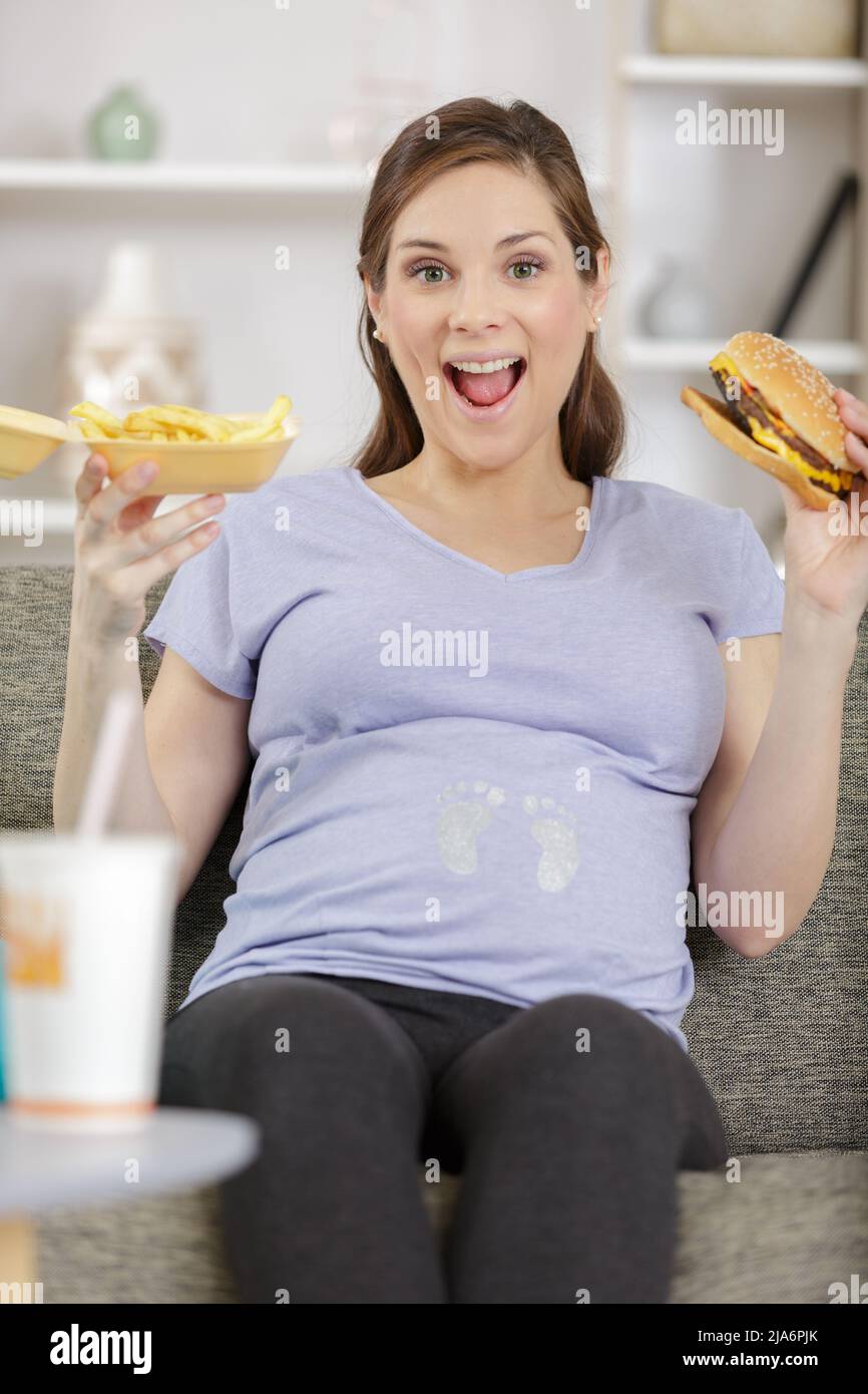 portrait of pregnant woman with plate of junk food Stock Photo Alamy