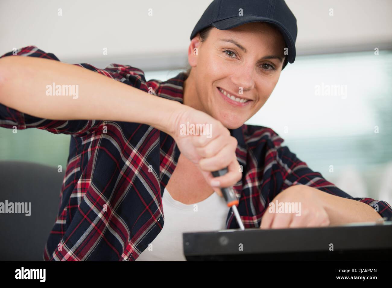 female technician using a screwdriver for fixing printer Stock Photo