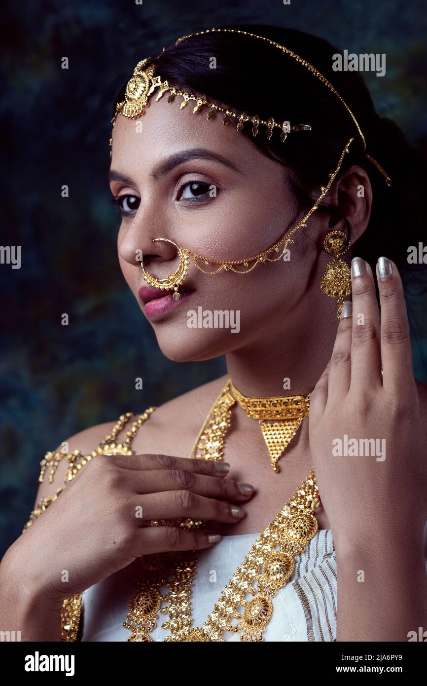 Indian Female Model Wearing A White Saree And Gold Jewellry Sporting A Bengali Traditional Saree