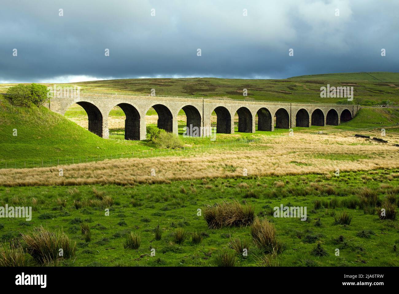 The arched railway viaduct at the top of Garsdale in Cumbria on a sunshine/rain afternoon Stock Photo