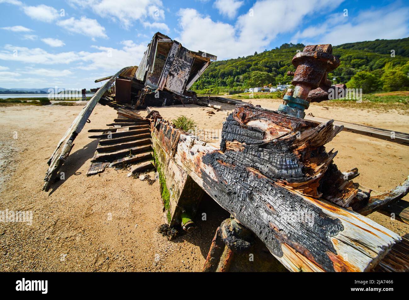 Beach shipwreck falling apart after fire on beach Stock Photo