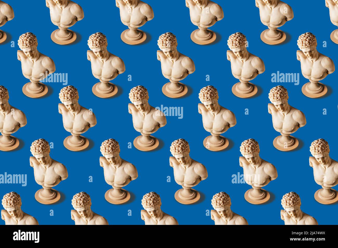 Creative pattern made of old statues on blue background. Minimal art concept. Stock Photo