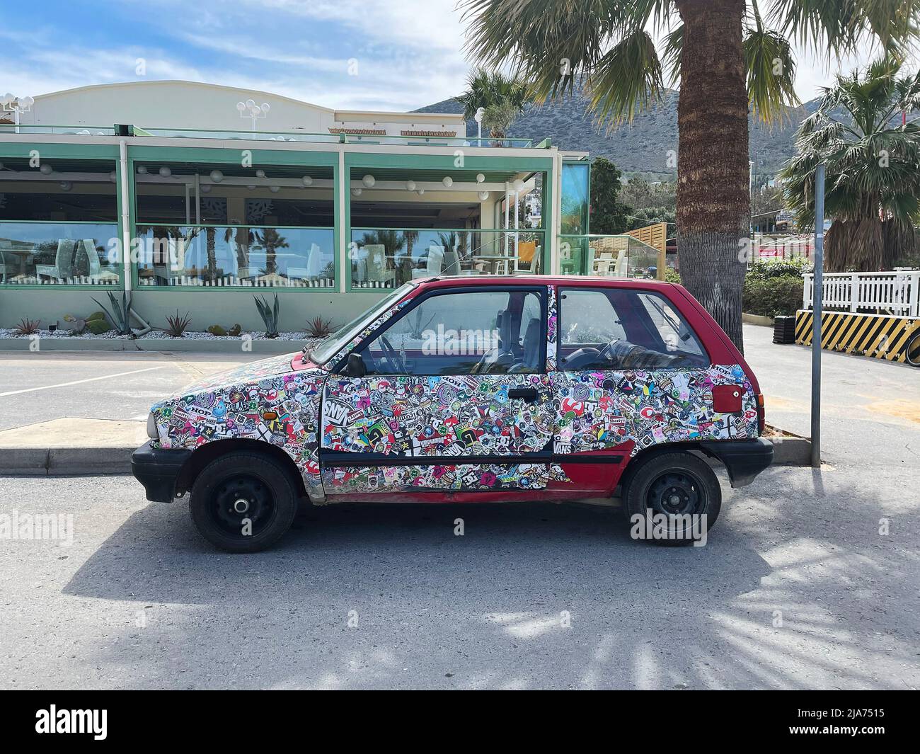 Greece, Heraklion. May 12, 2022: Red car full of stickers on the street. Stock Photo