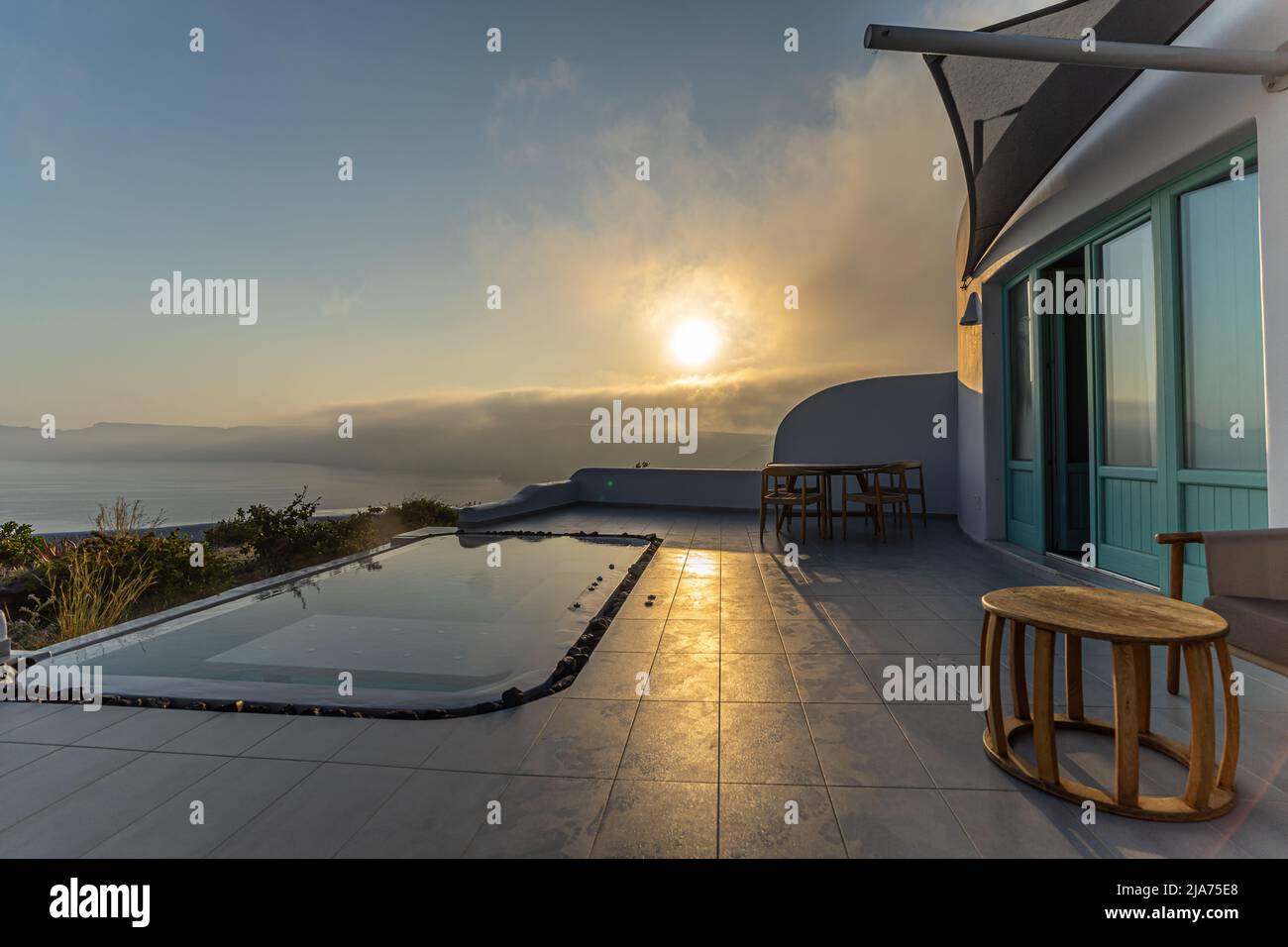 A pool on the patio of an elegant apartment reflects the early morning sunlight Stock Photo