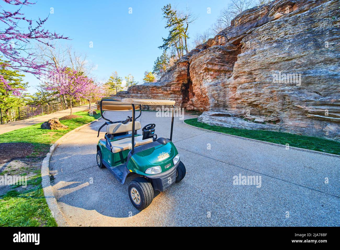 Golf cart on stunning paved path in spring next to cliffs Stock Photo