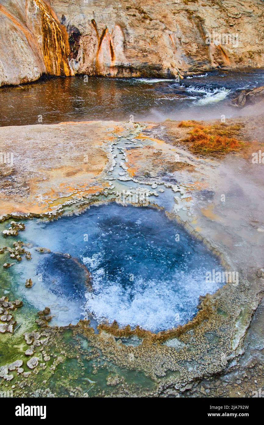 Amazing chinese bubbling hot spring by river in Yellowstone Stock Photo