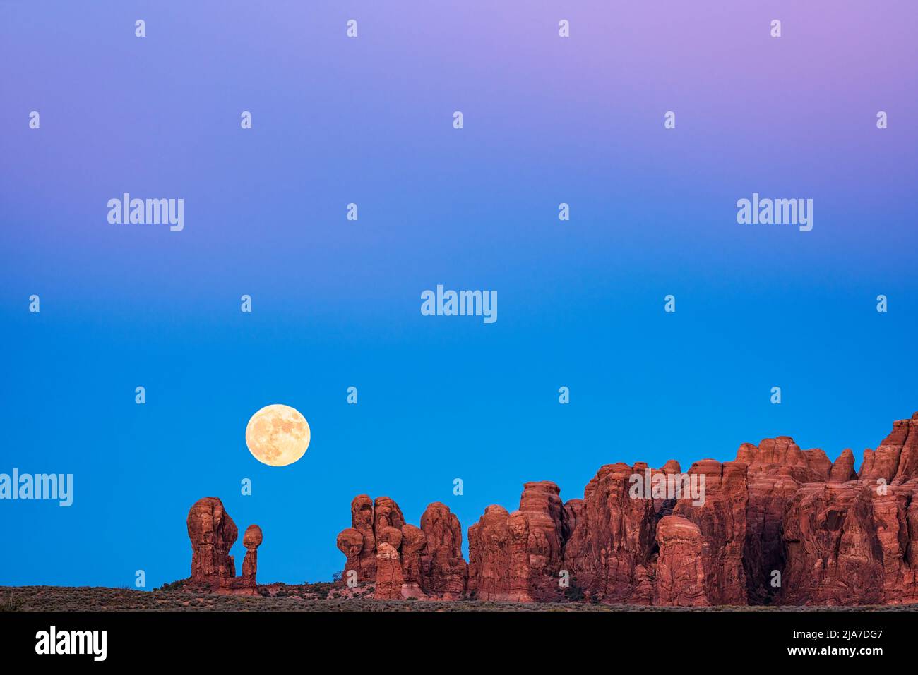 Moon rise at twilight in the Garden of Eden section of Arches National Park in Utah Stock Photo