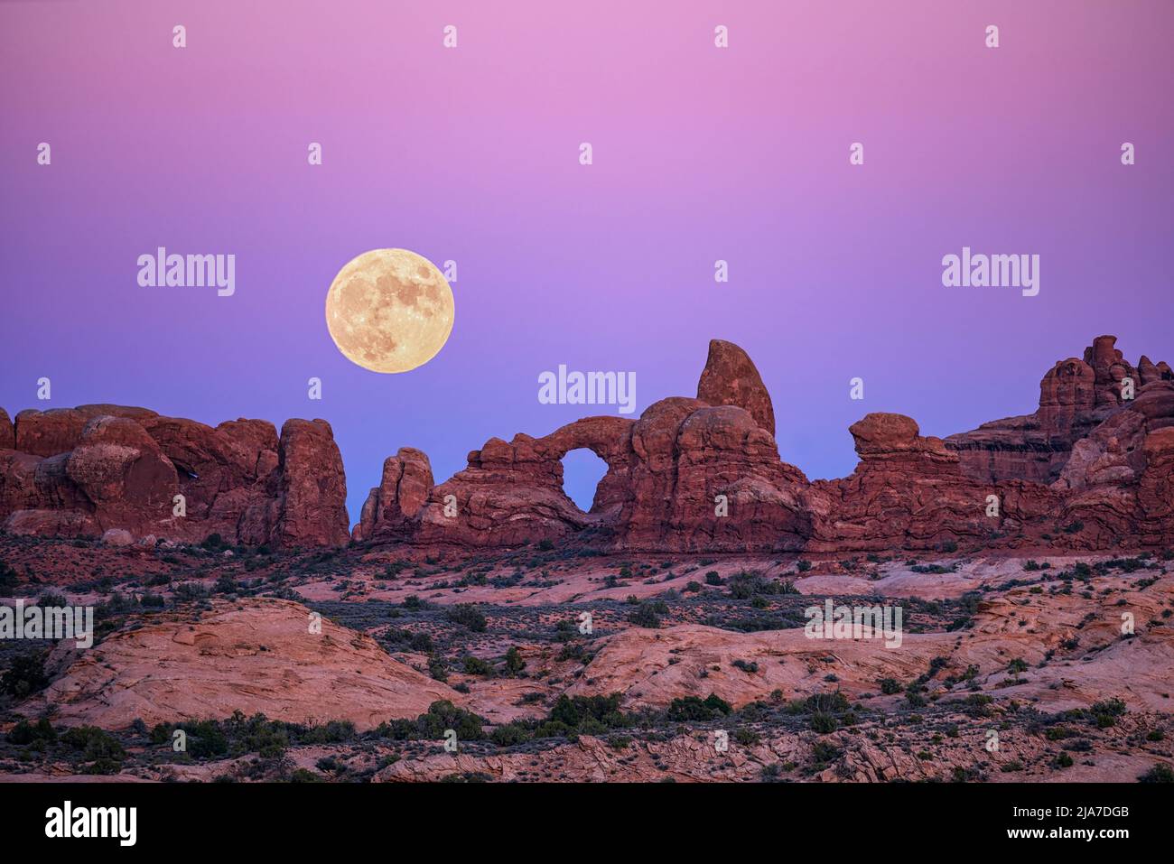 Turret Arch and rising moon in Arches National Park Stock Photo