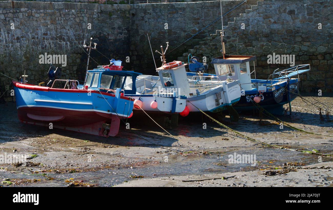 Small fishing boats in Porthleven harbour at low tide Stock Photo - Alamy