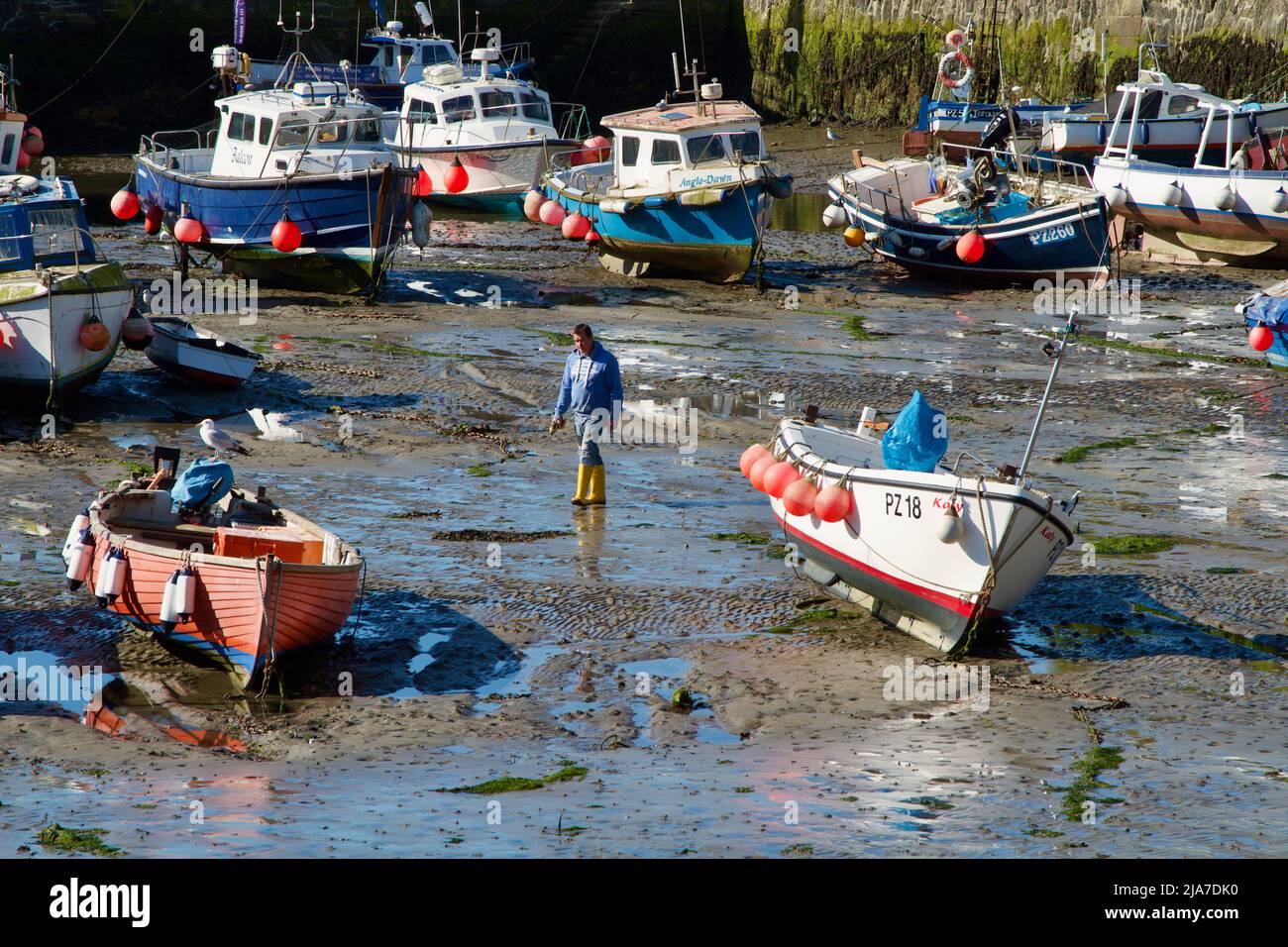 Small fishing boats in Porthleven harbour at low tide Stock Photo - Alamy