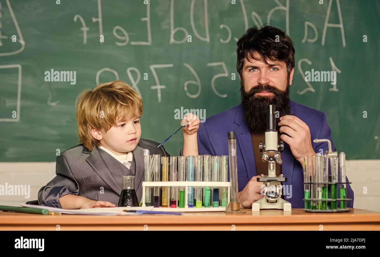 I love study in school. Teacher and pupil boy in chemical laboratory ...