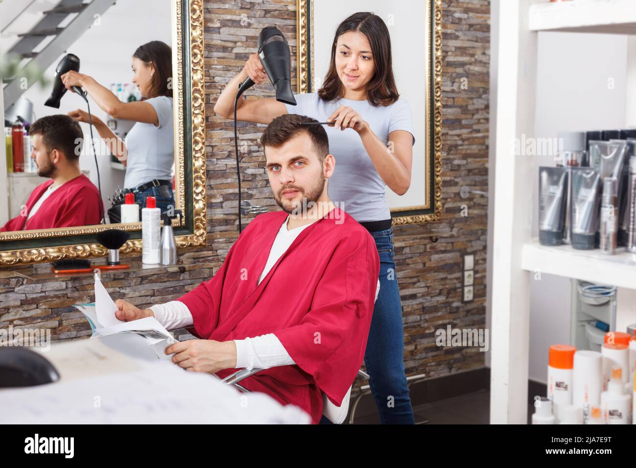 Young woman hairdresser drying hair with blow dryer of guy Stock Photo ...