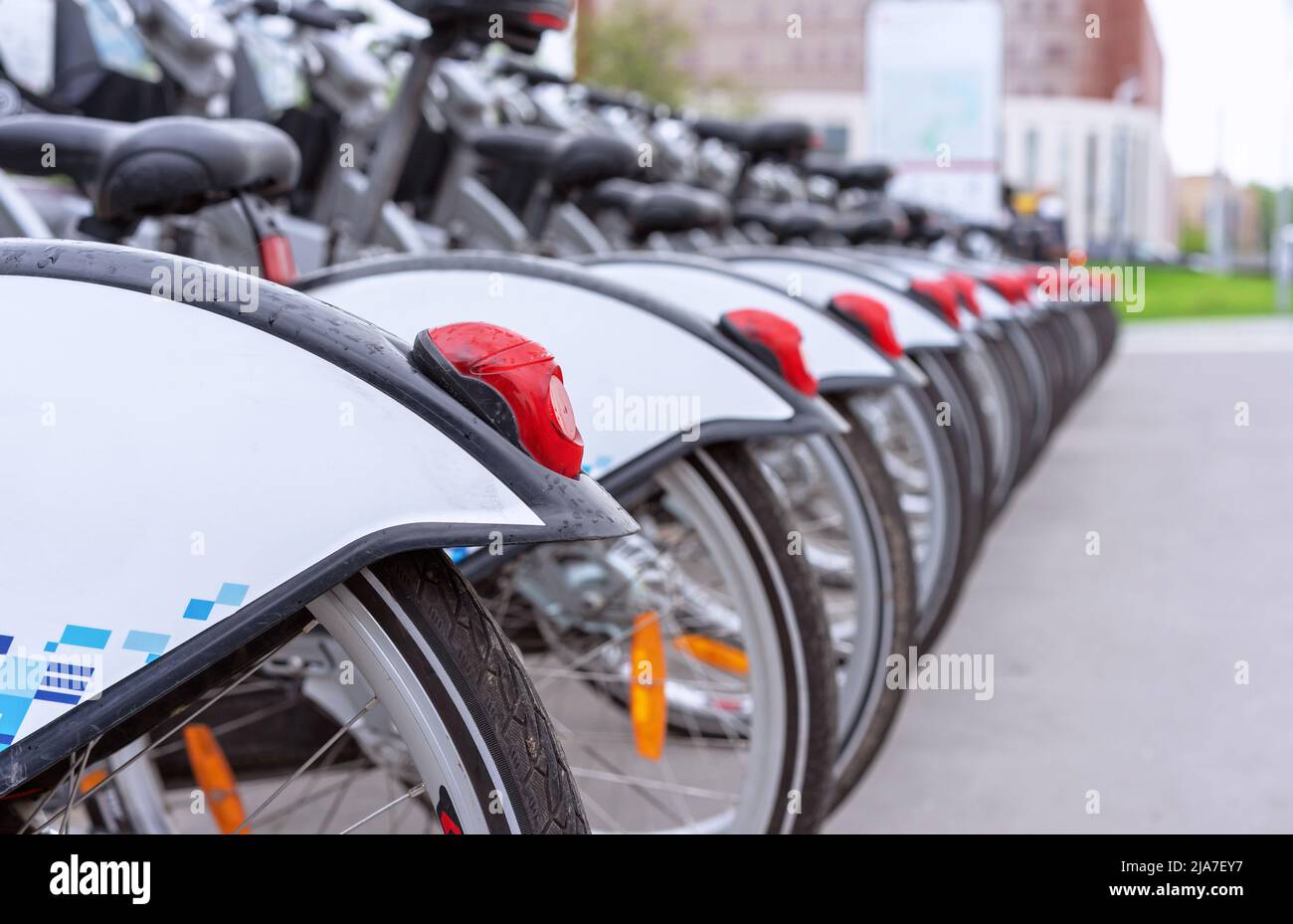 Red tail lights on rental bikes. Row of bicycles on the bike parking