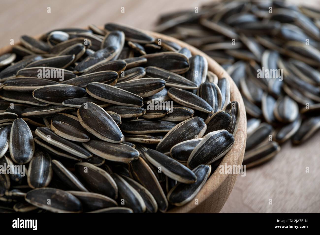 Black sunflower seeds in a bowl on wooden background Stock Photo