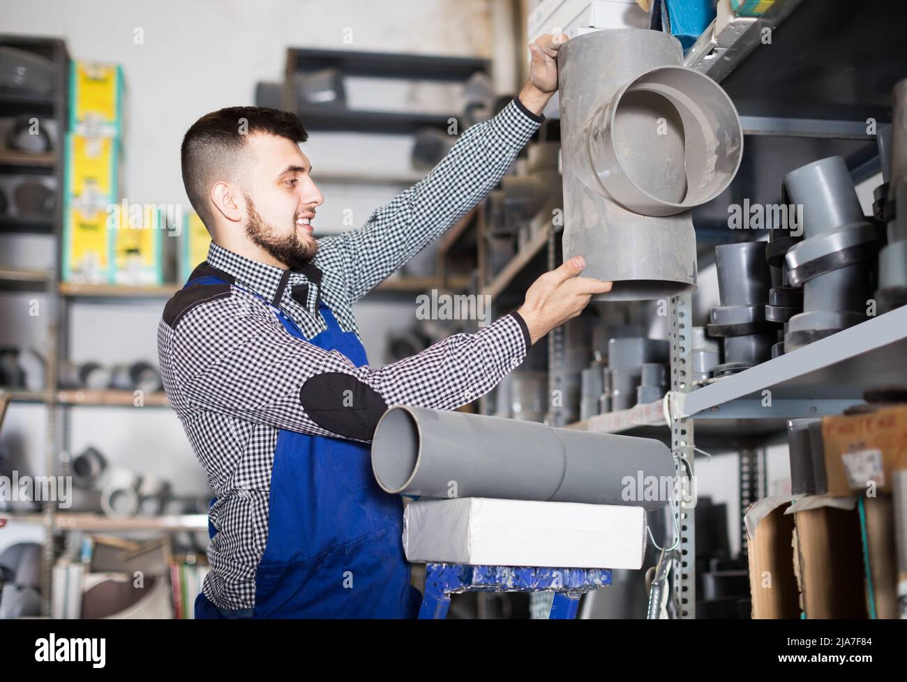 Worker examining a diverse selection of sanitary pipes Stock Photo Alamy