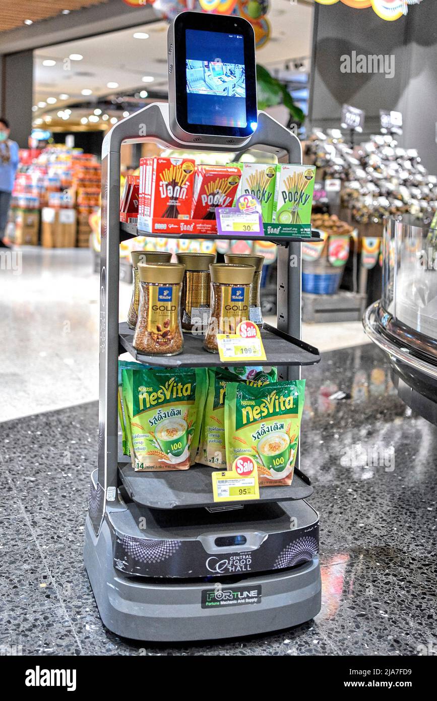 Robot machine navigating through the supermarket aisles  and promoting stock. Thailand Southeast Asia Stock Photo
