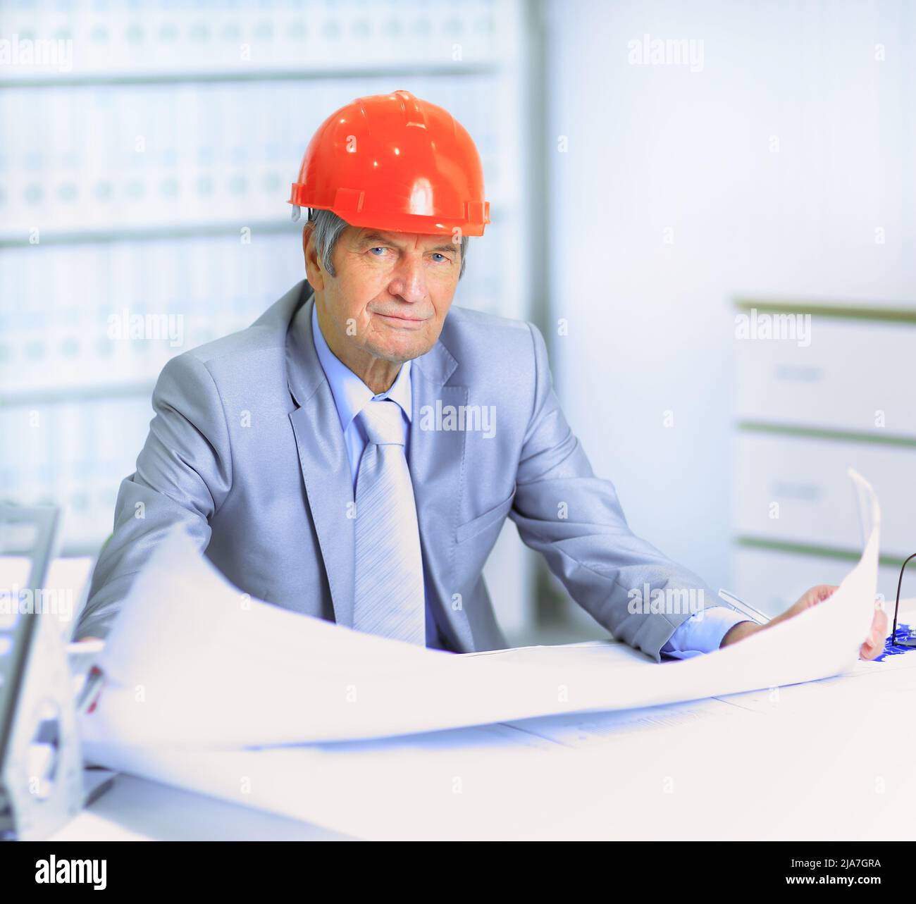 Engineer at the age of considering plans drawing and corrects them ...