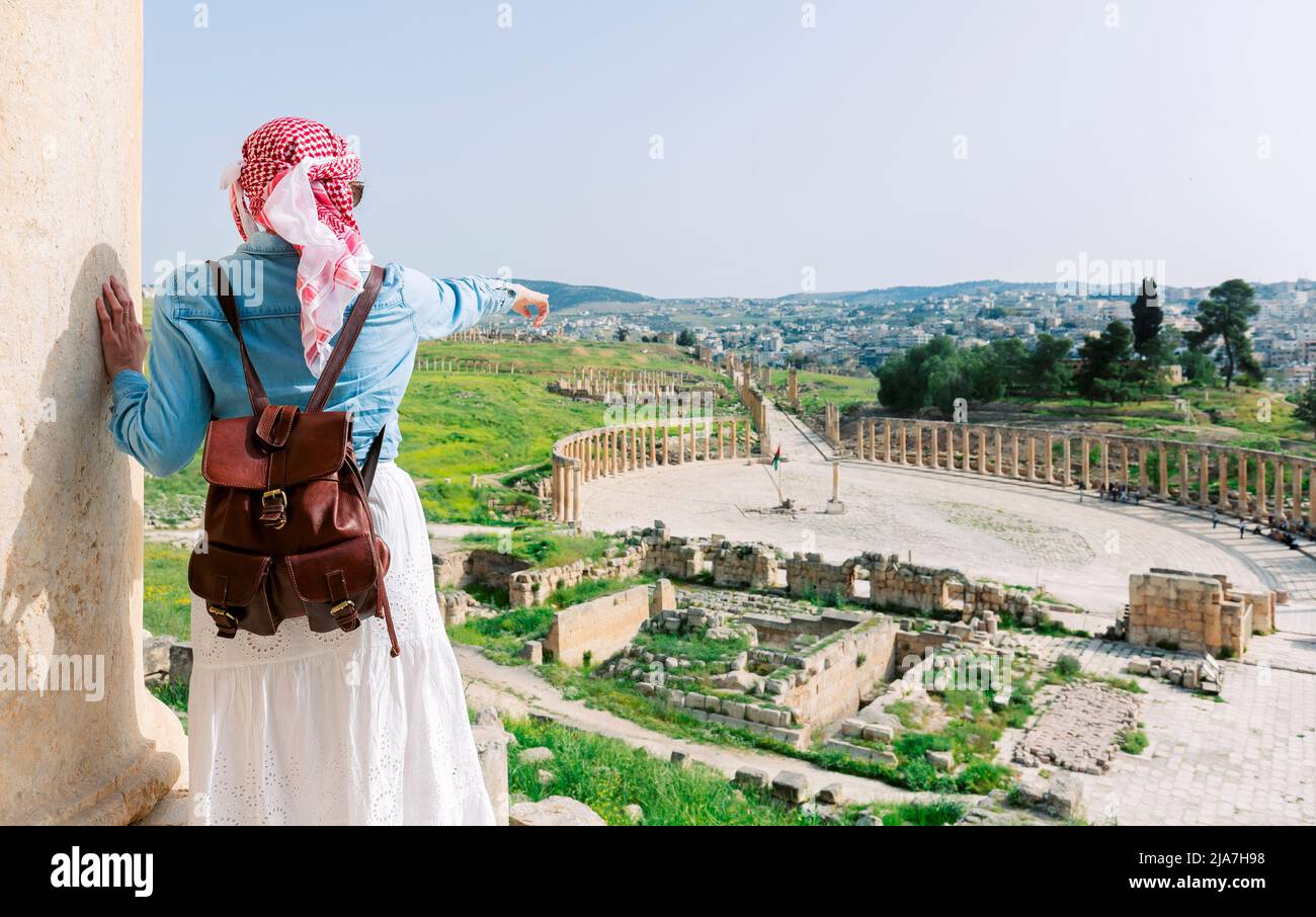 Jerash - jordan. travel tourism holiday background -young girl with hat standing pointing to Ancient Roman city of Gerasa of Antiquity, Jerash Stock Photo