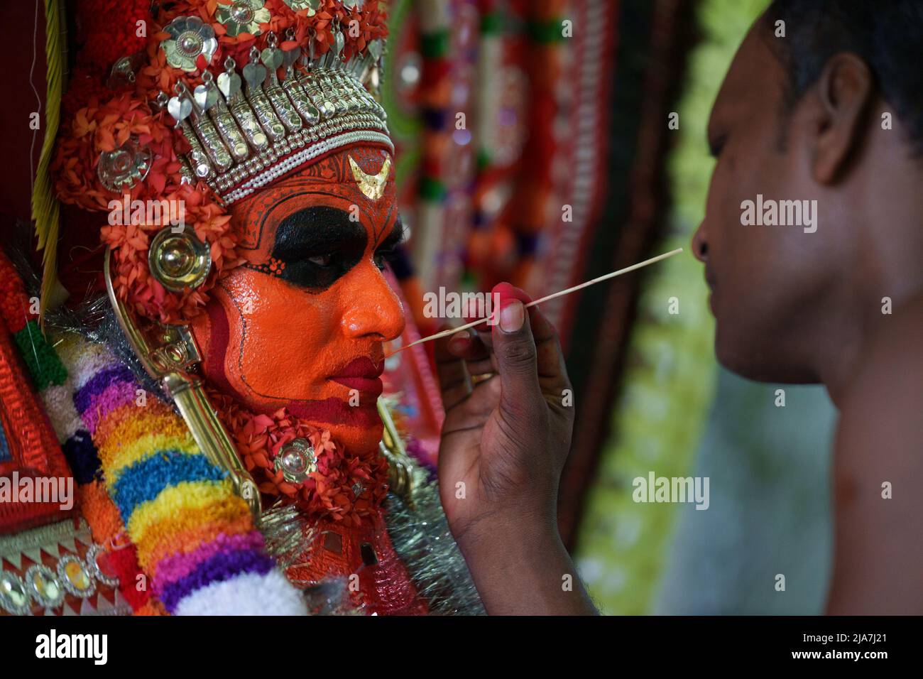 Theyyam is a famous ritual art form in kerala with face painted using organic colors and use musical instruments as Chenda, Elathalam, , Kurumkuzal Stock Photo