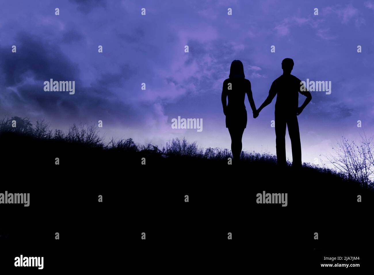 silhouette of a couple hand in hand at evening along a ridge Stock ...