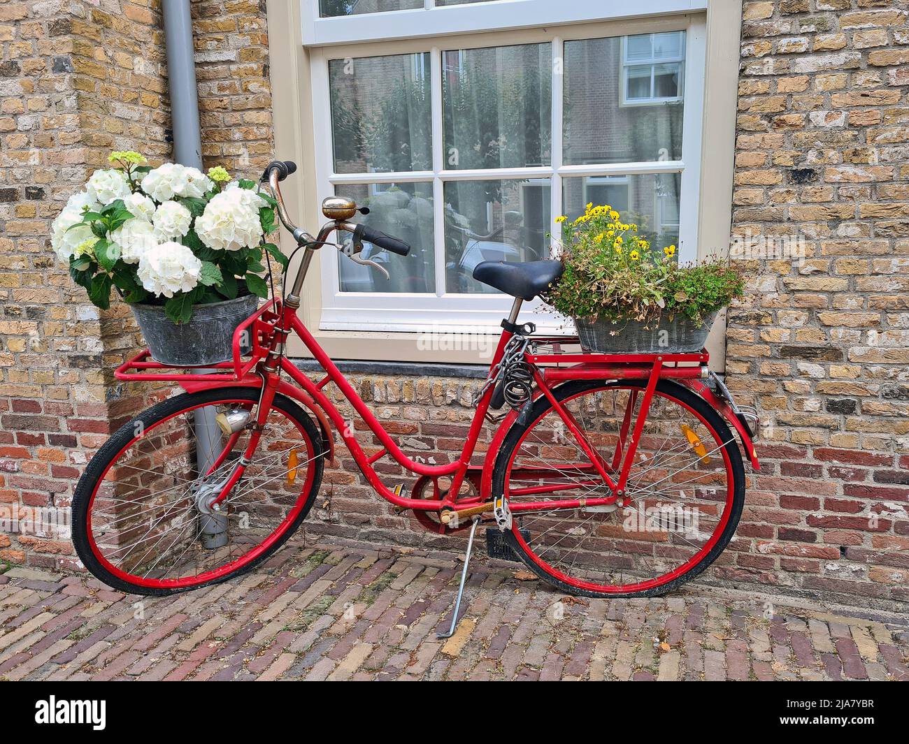 Typical dutch: old red dutch bike with blossoming flowers in the Netherlands Stock Photo