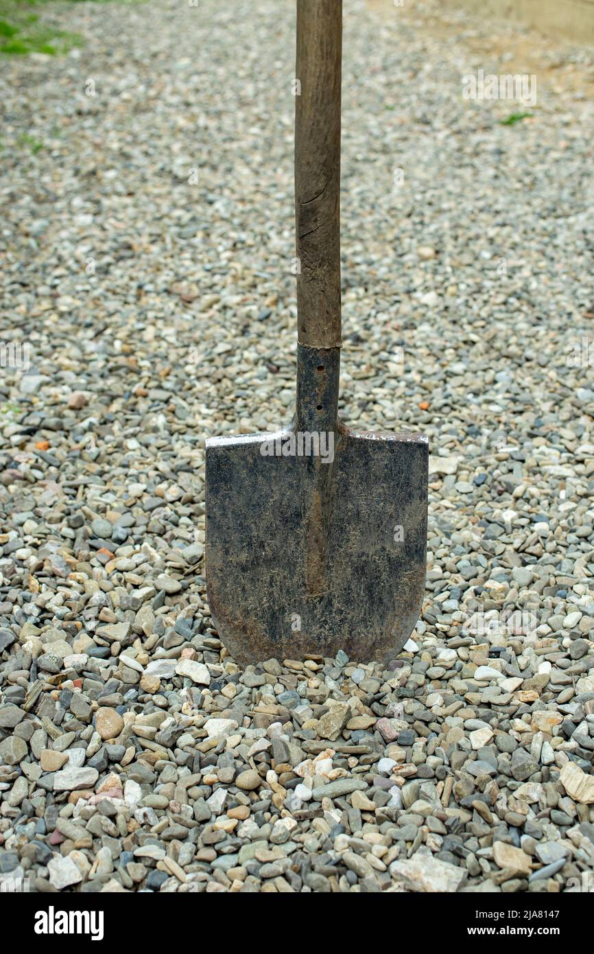 spade digging in gravel, impossible construction concept Stock Photo