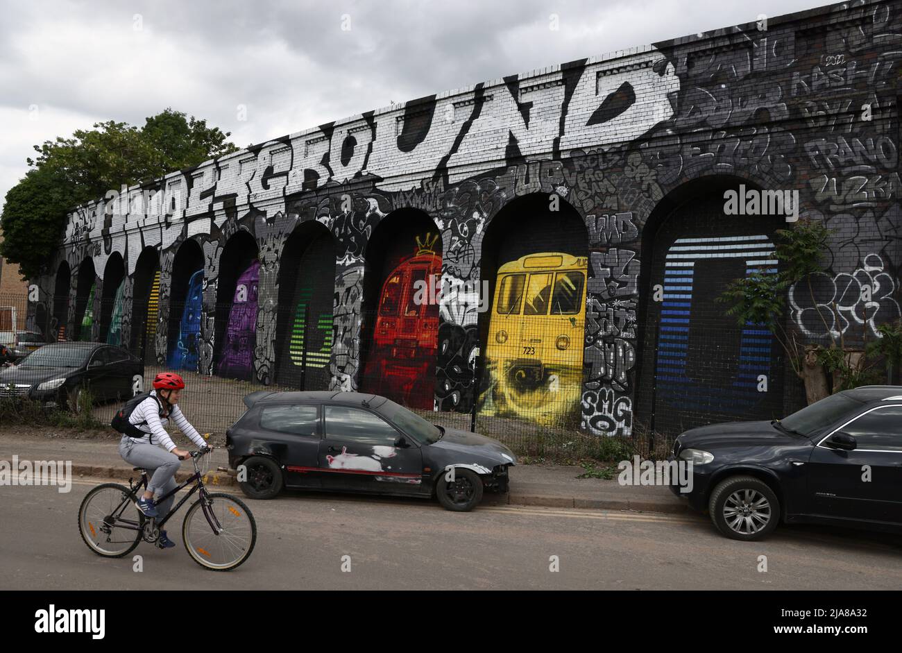 Leicester, Leicestershire, UK. 28th May 2022. A cyclist rides past a spray painted mural during