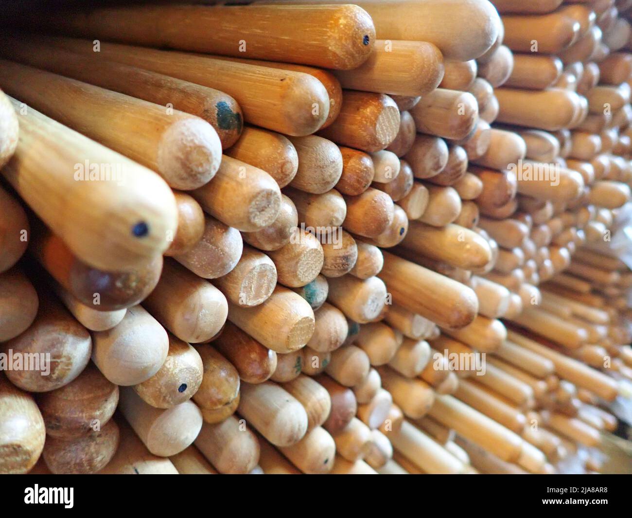 The ends of 100s of drumsticks piled together in a compartment Stock