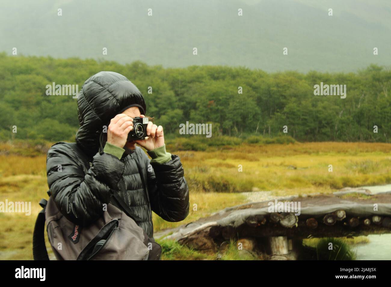 Mujer tomando una foto analógica en paisaje Stock Photo