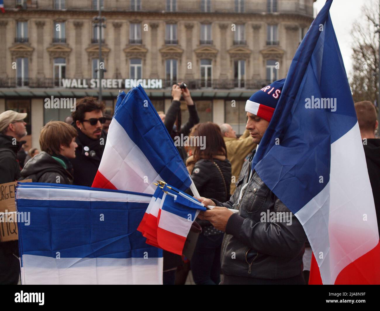 Man with French flags when thousands took the streets of Paris and rally for a fair  global agreement  at COP21 negotiations, being held in Le Bourget. They demanded nations to reach the goal of 1.5° as top for global warming. Stock Photo