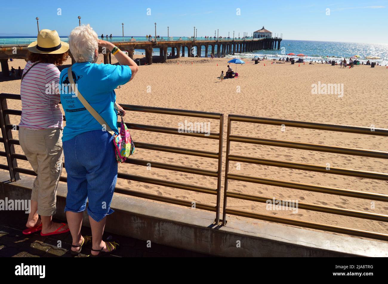 Two senior women gaze out to the Pacific Ocean at Manhattan Beach, California Stock Photo