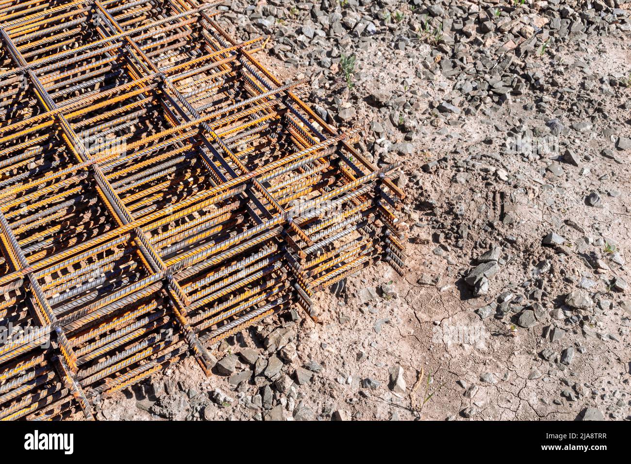 reinforcing frame mesh covered with rust lies on the ground, waiting to be raised to the mounting horizon, selective focus Stock Photo