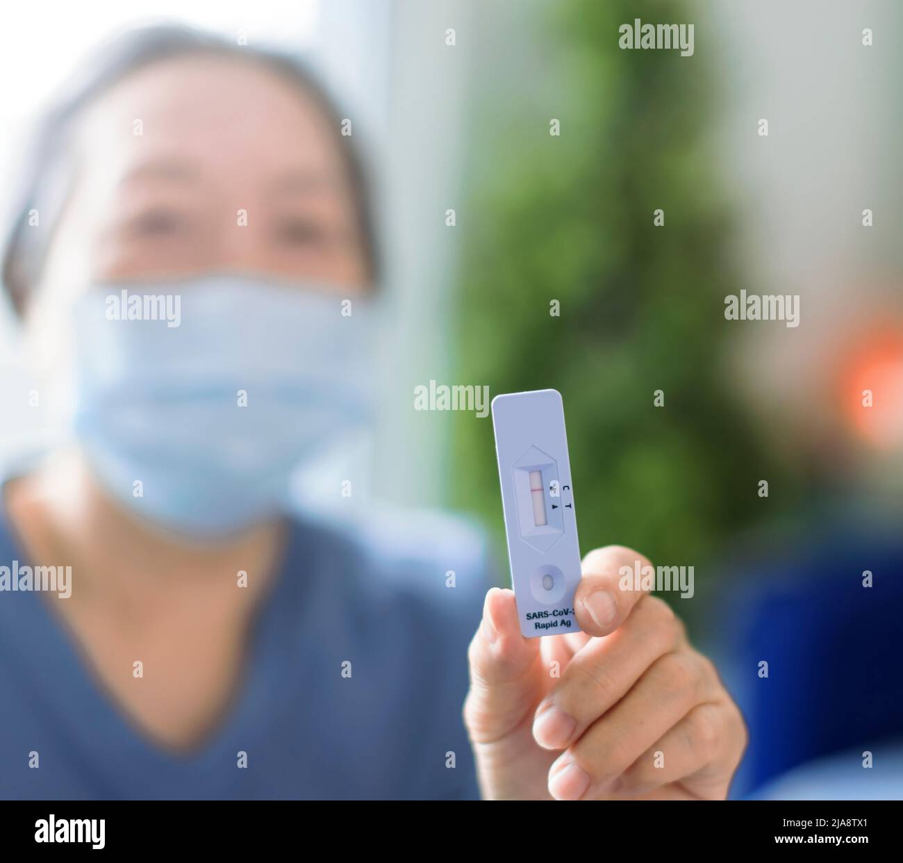 Senior Woman showing antigen self test card with negative result for  Covid-19 Stock Photo