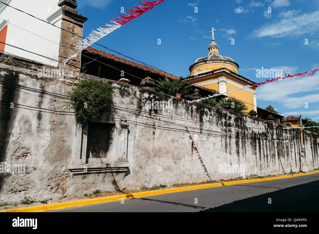Stone wall, yellow cupola, blue sky - Granada, Nicaragua Stock Photo