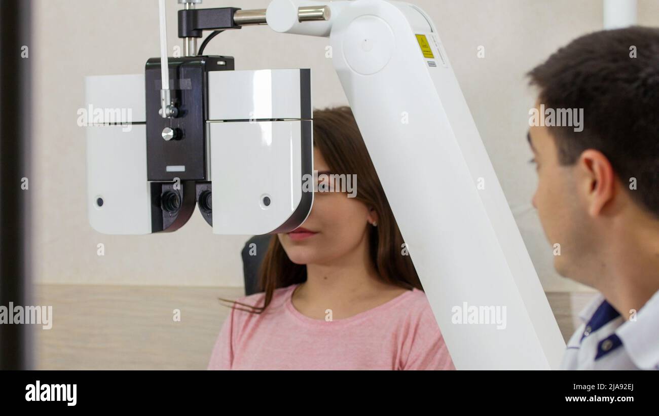Ophthalmology treatment - a young woman checking her visual acuity with ...