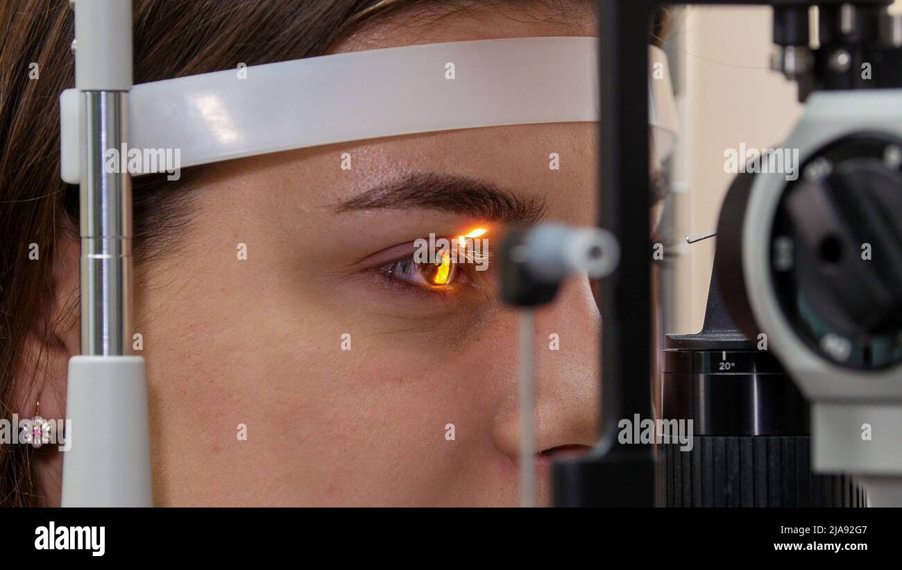 Ophthalmology treatment - a young woman checking her visual acuity with ...
