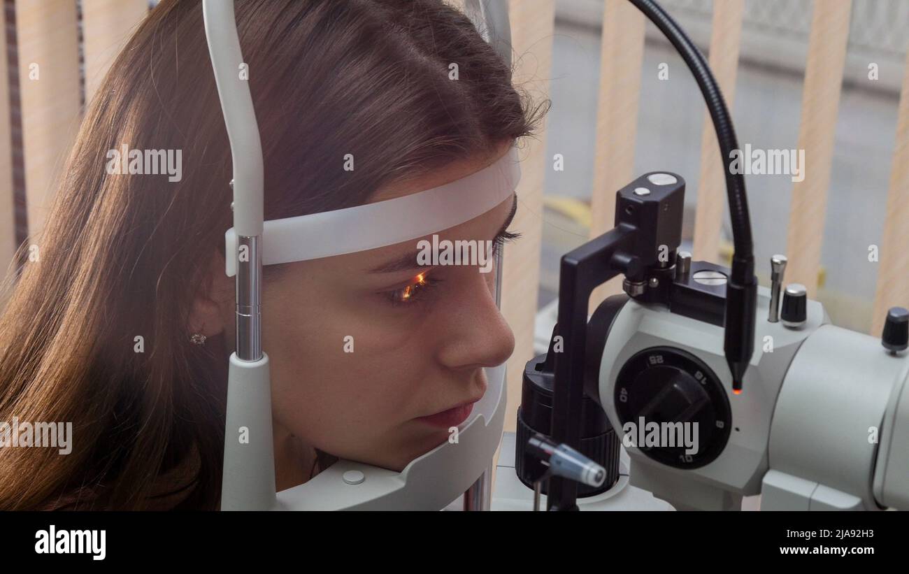 Ophthalmology treatment - a young woman checking her visual acuity with ...