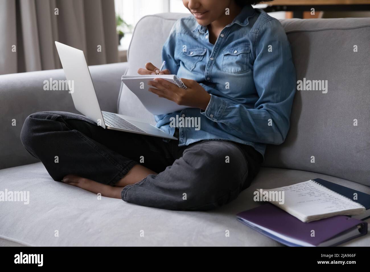 Black teenage schoolgirl studying at home, doing school home task Stock Photo