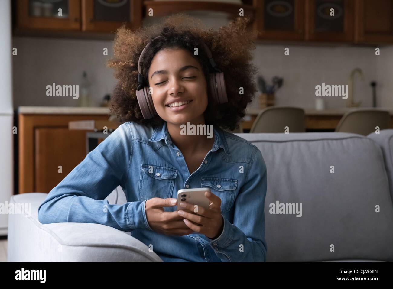 Happy gen Z teenage African girl in big wireless headphones Stock Photo ...