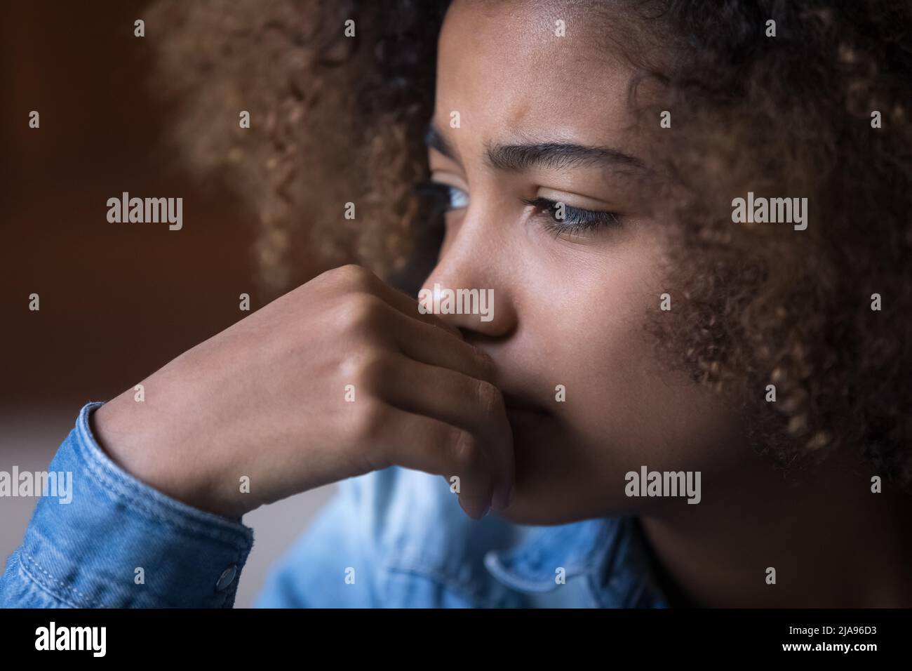 Sad concerned Black teenage girl thinking over problems Stock Photo