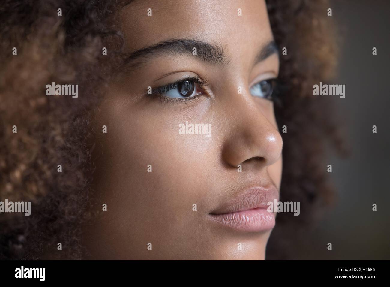 Close up face serious young Afro American woman looking aside Stock Photo