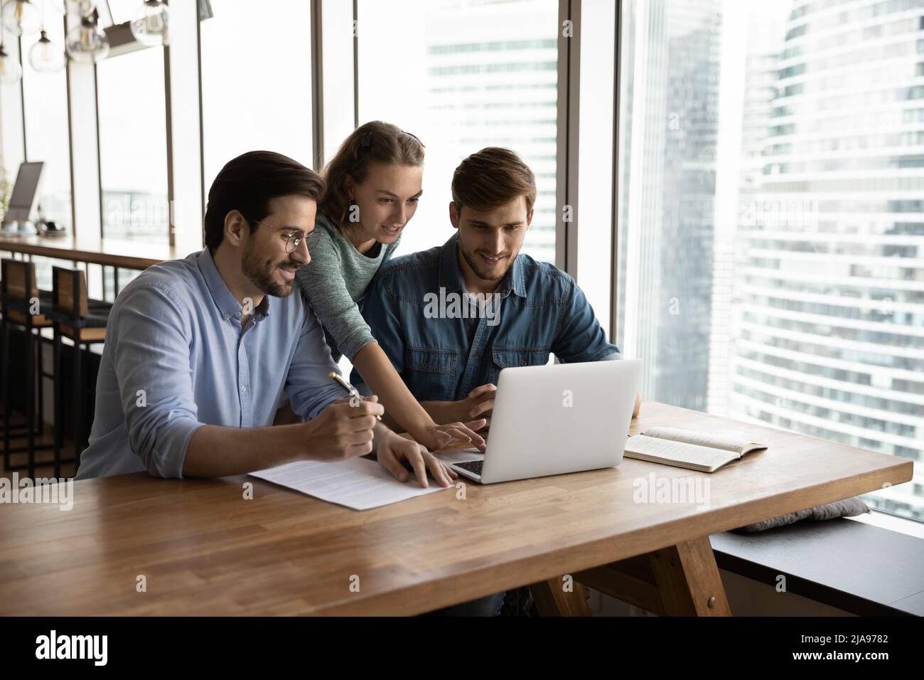 Creative business team sharing laptop in office Stock Photo