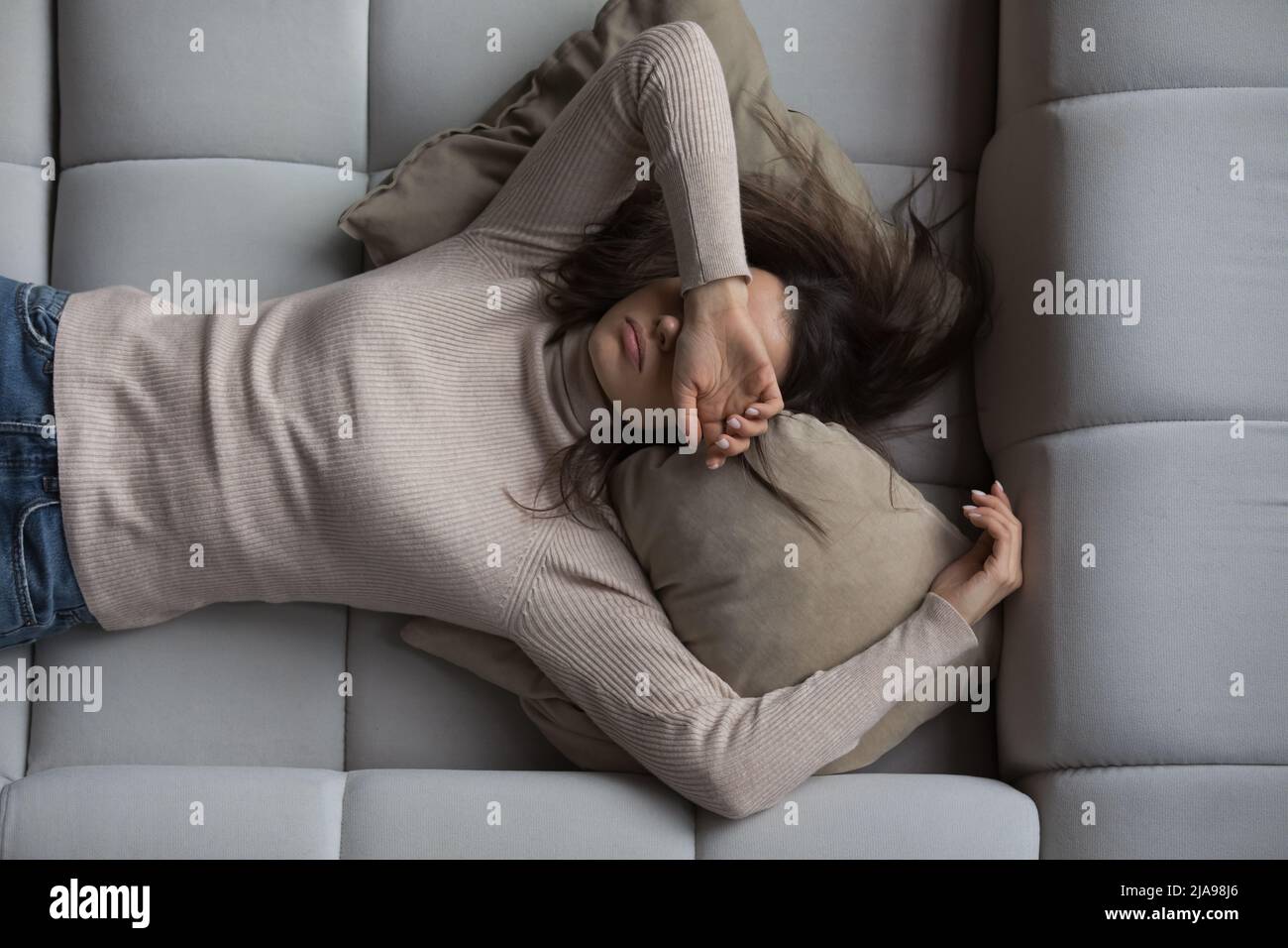 Peaceful girl lying on back on comfortable couch at home Stock Photo