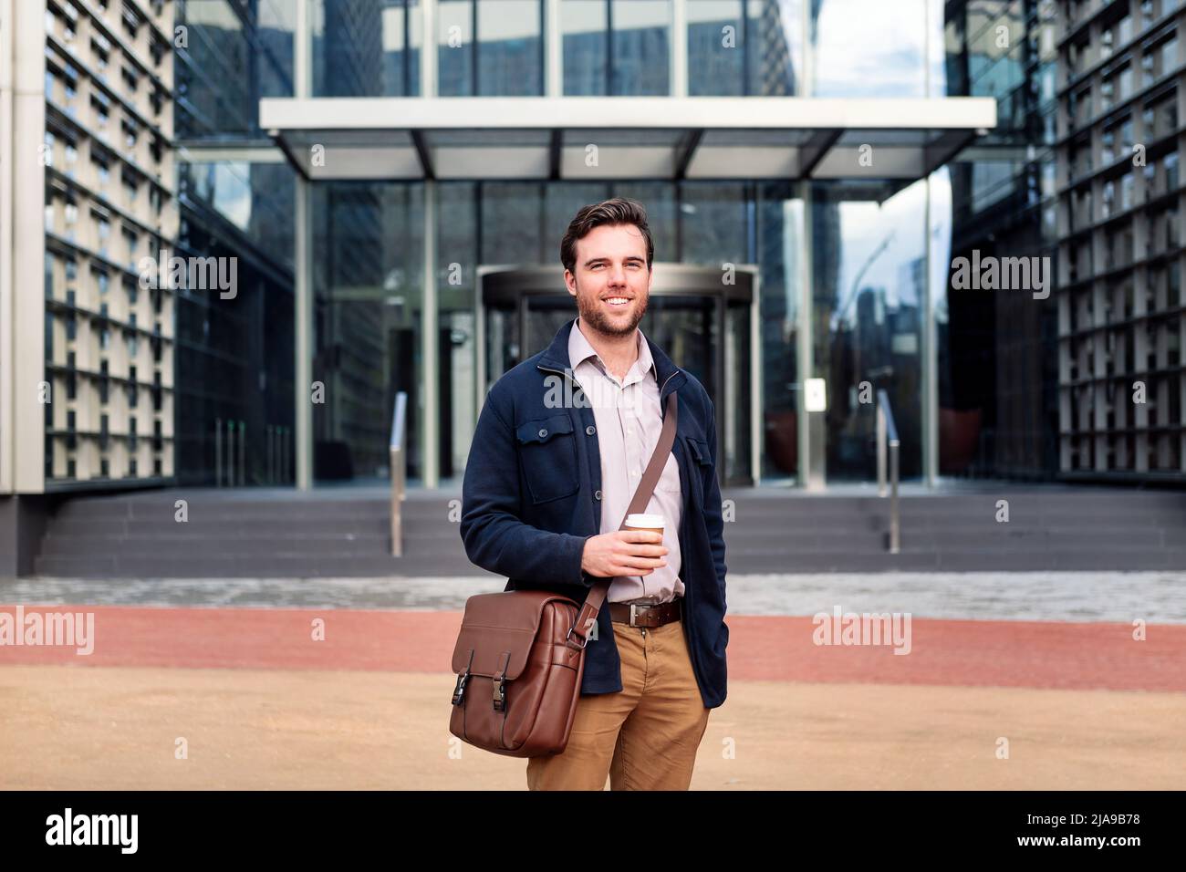 smiling business man in front of office building Stock Photo