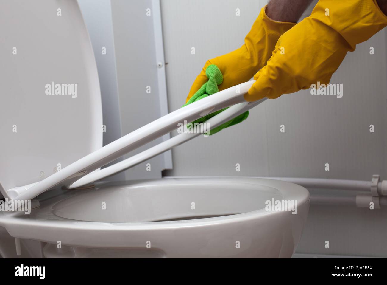 Disinfect, sanitize, hygiene care concept. Man cleaning toilet seat lid Stock Photo Alamy