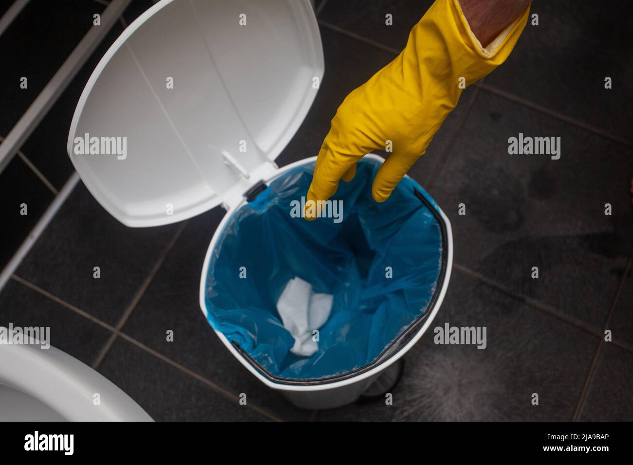 Toss napkin into trash in the bathroom. Disposing toilet paper, putting