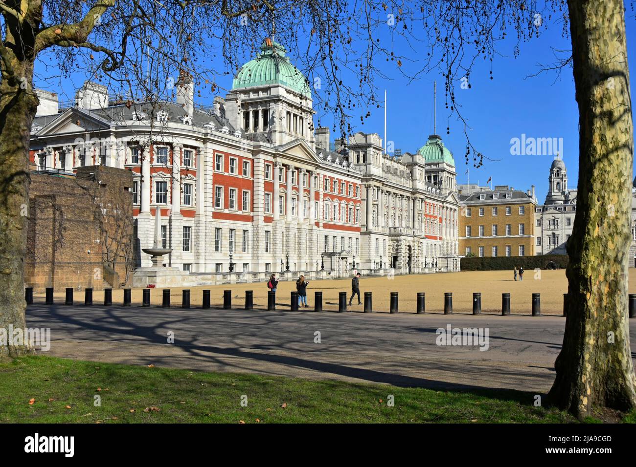 Admiralty Extension a red brick white stone building fronting the gravel Horse Guards Parade Ground flanked by bollards on Horse Guards Road London UK Stock Photo