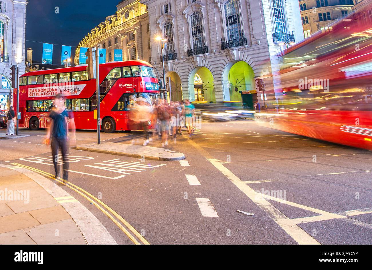 LONDON, UK - JULY 3RD, 2015: Red Double Decker bus speeds up at night in Piccadilly Circus Stock Photo